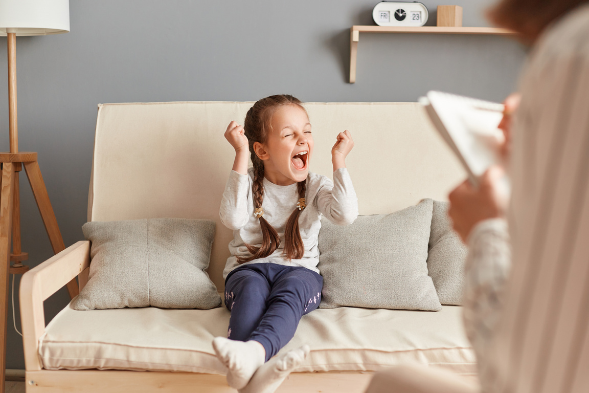 Doctor psychologist on consultation with little cute girl, child with clenched fists, hysterical behavior, mental health treatment, psychiatrist appointment.